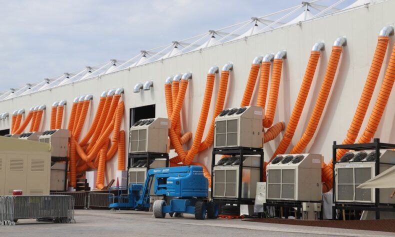 Modern industrial cooling units with striking orange ducts outside a building. - Photo by Oguz Dik on Pexels