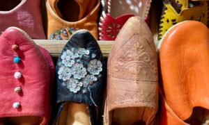 Vibrant Moroccan babouche slippers in various colors on display, showcasing traditional Moroccan craftsmanship. - Photo by Abdel Achkouk on Pexels