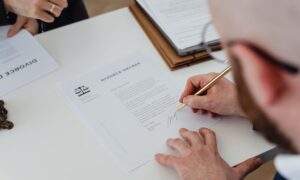 Close-up of a person signing a divorce decree on a desk. - Photo by https://kaboompics.com/ on Pexels