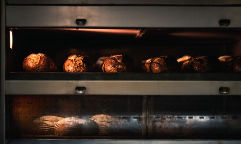 Warm artisan bread being baked to perfection in a professional industrial oven. - Photo by Chris F on Pexels