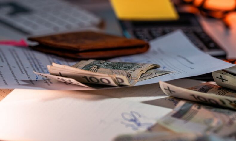 Zloty banknotes and financial paperwork scattered on a desk, representing budgeting and finance. - Photo by Jakub Zerdzicki on Pexels